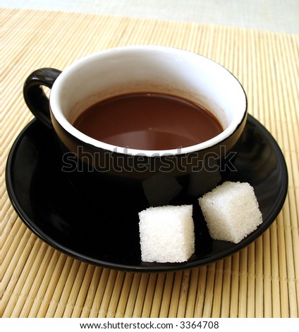 cup of coffee with two pieces  of sugar