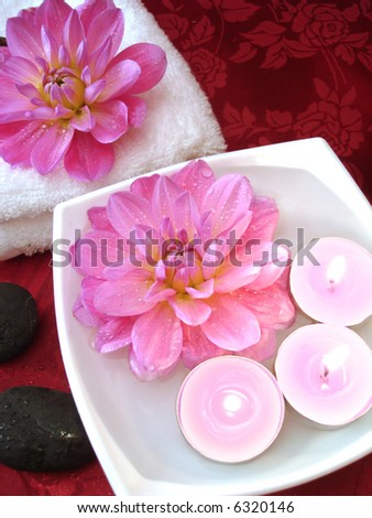 Spa essentials (candles, flowers on water, towel and stones)