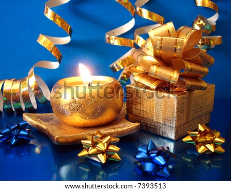 golden candle and gift box on blue background