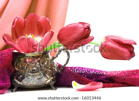red flowers in vase with fabric