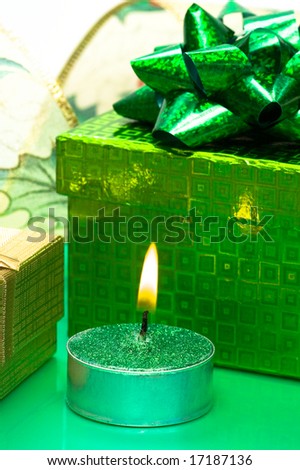 green gift box and burning candle