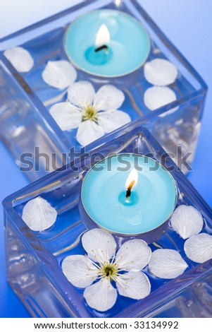 Candle with spring flowers in water