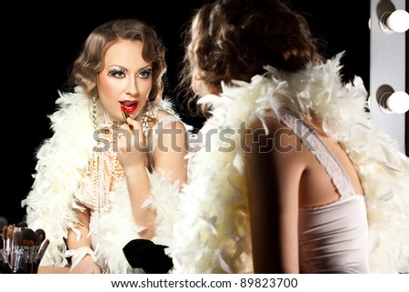 fashionable woman with make-up brush near the mirror