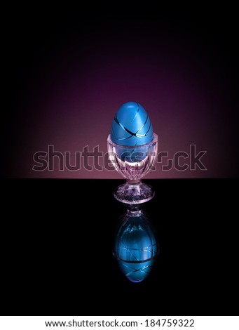 Decorative blue colored Easter egg in a cup.  Isolated on white.