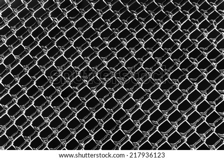 An abstract background image of a color inverted chain link fence processed in black and white.  The diamond pattern is partially covered in an ice texture.