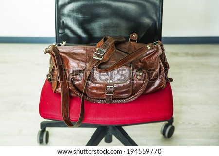 Luxury travel leather bag on office red chair