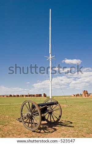 Civil war era cannon and flagpole on the parade ground at old Fort Union National Monument north of Santa Fe, New Mexico - vertical orientation.