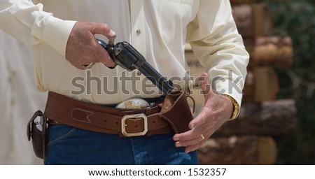 A man draws and  cocks a single action pistol from a cross-draw western holster