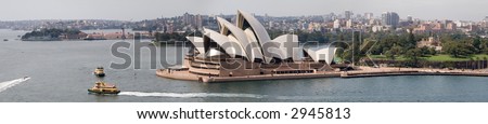 True wide panorama of the world-famous Sydney Opera House on the harbor at Sydney, Australia, taken from the eastern side of the harbor, with two harbor ferries in the foreground