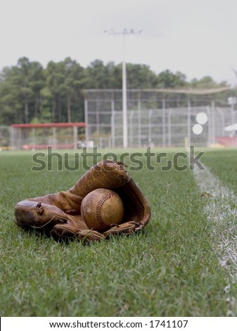 Old Baseball Glove and Ball With Field in Background