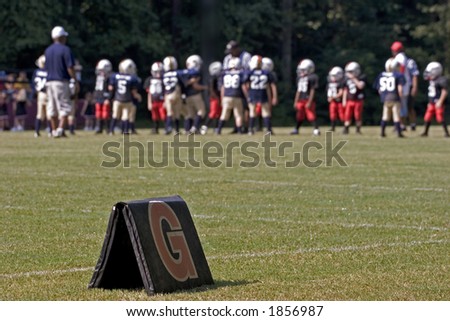 Goal Line marker with peewee football game in background.  Shallow depth of field with focus on marker.