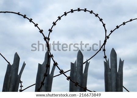 Razor wire and spiked steel posts as security fence.