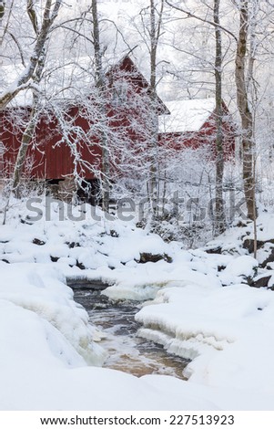 Barns at a river with snow and ice