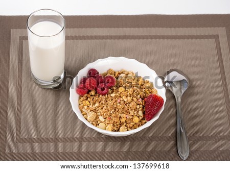 Cereals in bowl with berries and milk glass