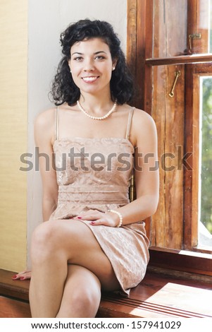 Pretty woman on sill and wide bright smile