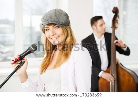 Woman with microphone and man play on contrabas