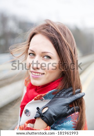 Zoomed young woman flapping hair at windy day
