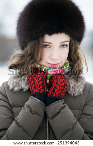 Woman in colored mittens looking shy and calm