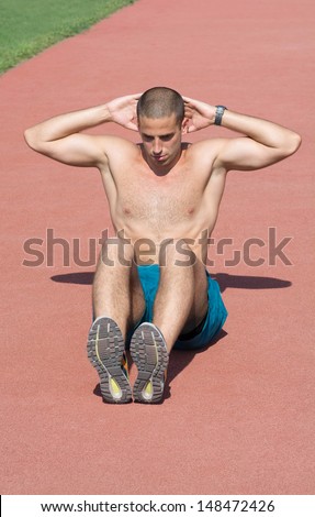 Muscular man doing exercise outdoors.