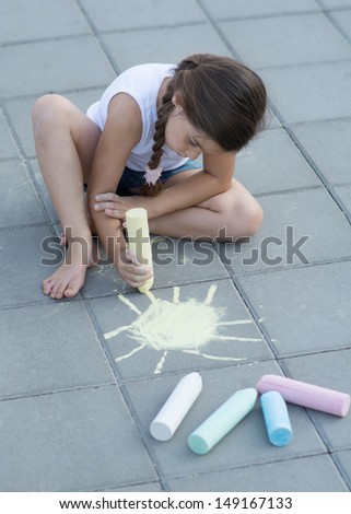 Little Girl Drawing on the sidewalk