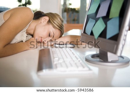 A young woman asleep at her computer