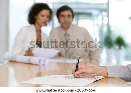 writing notes at a boardroom meeting