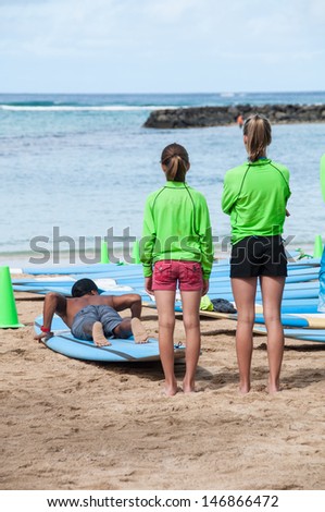 WAIKIKI, HI - JUNE 23 - Tourists learning to surf on Waikiki beach June 23, 2013 in Oahu. Waikiki beach is beachfront neighborhood of Honolulu, best known for white sand and surfing.
