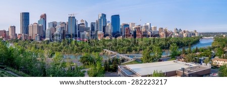 CALGARY, CANADA - MAY 24: Calgary\'s skyline with the Bow River in the foreground May 24, 2015. The Peace Bridge is visible on the far right and the Bow Tower on the far left.