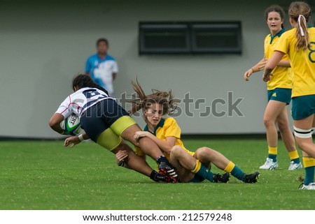NANJING, CHINA-AUGUST 19: Australia Rugby Team (yellow) tackles USA Rugby Team (white) during semifinals match of 2014 Youth Olympic Games on August 19, 2014 in Nanjing, China. Australia wins 33-0.