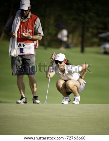PATTAYA THAILAND - FEBRUARY 18: American golfer Michelle Wie thinks of the next move during Day 2 of Honda LPGA Thailand on February 18, 2011 at Siam Country Club Old Course in Pattaya, Thailand