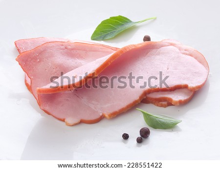 Three pieces of pork loin with fresh green basil on the white background