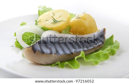 Piece of jack mackerel with boiled potato, onion and lettuce on the plate