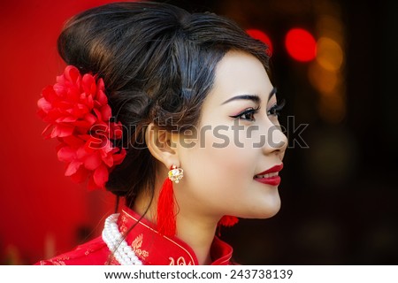 China Girl ,Chinese woman red dress traditional cheongsam ,close up portrait with red wood door