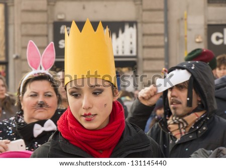 MILAN, ITALY - FEBRUARY 16: young pretty woman wearing a light mask, in background others masks. Shot at Kid\'s Carnival parade on Minster square on feb 16, 2013 Milan, Italy