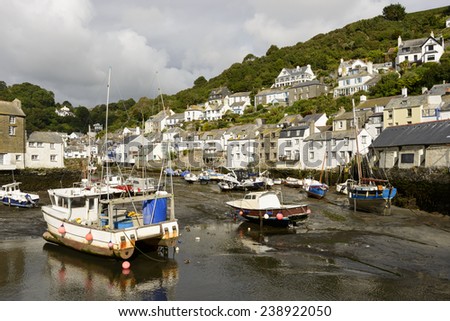 low tide in village harbor, Polperro, cityscape of the touristic village on southern coast of Cornwall with low tide in the river harbor and boats aground