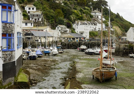 dry harbor at Polperro village, Cornwall, cityscape of the touristic village on southern coast of Cornwall with low tide in the river harbor and boats aground