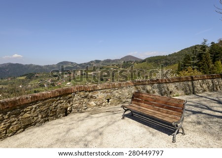 view of  walk with a bench overlooking Lunigiana landscape, shot on a spring sunny day, Fosdinovo, Italy