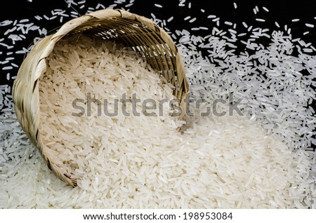 Basket of raw rice on black background
