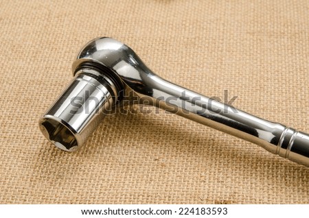 Image of socket wrench on brown sack background