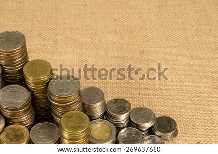 Stack of Thai baht coin on brown sack background