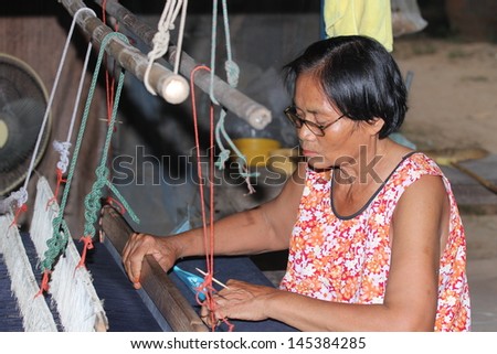 SISAKET, THAILAND - JUNE 16 : Thailand woman works as a weaver at June 16, 2012 in Sisaket, Thailand. This is extra work after season of peasant farming