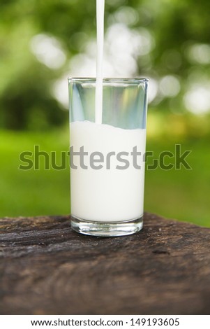 Milk pouring into a glass in outdoor