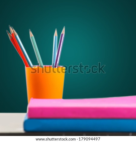 Pencils and book on table