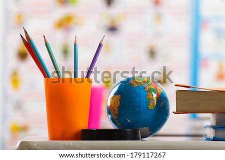 Pencils, globe and book on table