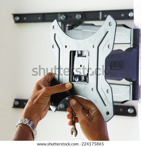 Man installing mount TV on the wall at home