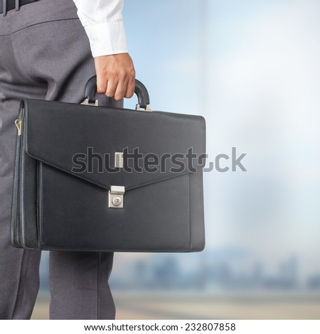 Cropped view of businessman holding a briefcase in the office