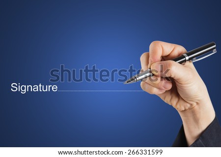 Fingers holding pen writing signature