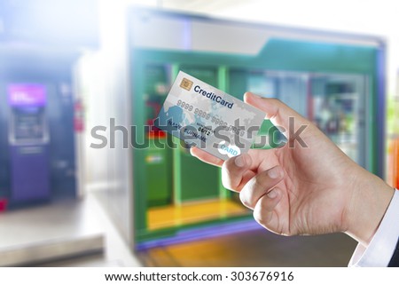 Hand holding credit card with ATM machines