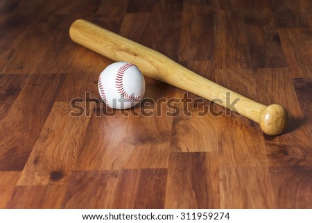 Baseball bat with ball on wood background