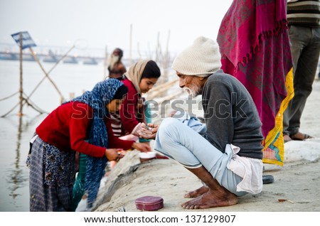 ALLAHBAD, INDIA - 28 JANUARY: Pilgrim makes an offering at the Kumbh Mela religious festival on 28 January 2013 in Allahbad. In 2013 it is estimated that 100 million people attended.